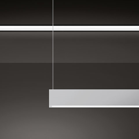 Artemide A.39 pendant lamp: slim rectangular LED fixture in white aluminum, suspended by a thin cable against a dark background