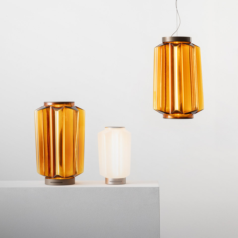 Artemide Auralia lamps: two amber ribbed glass table lamps and one matching pendant, plus a small white opal table lamp
