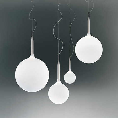Artemide Castore pendant lamps: four white opal glass spheres in varying sizes suspended by thin cables with tapered stems