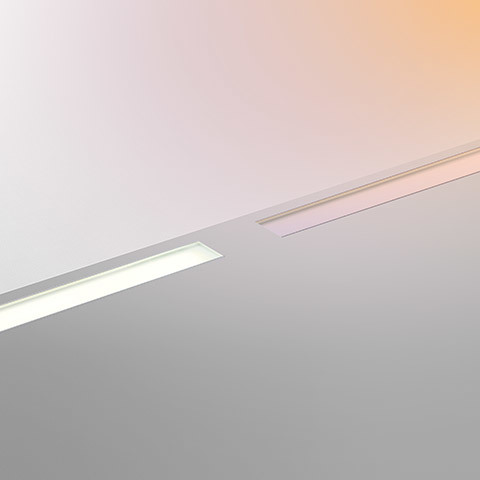 Artemide LineaLed Drive-over: due apparecchi LED lineari da incasso a soffitto, uno illuminato che emette luce bianca calda