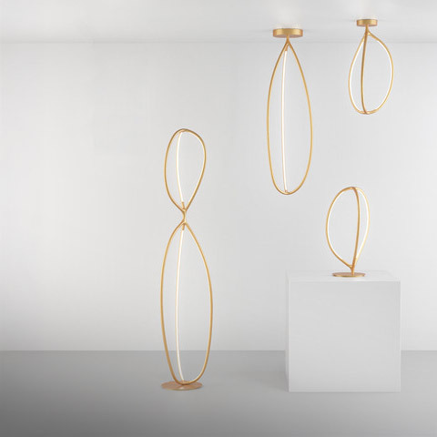 Artemide Arrival collection: three gold oval-loop LED lights in floor, ceiling, and table versions against a white background