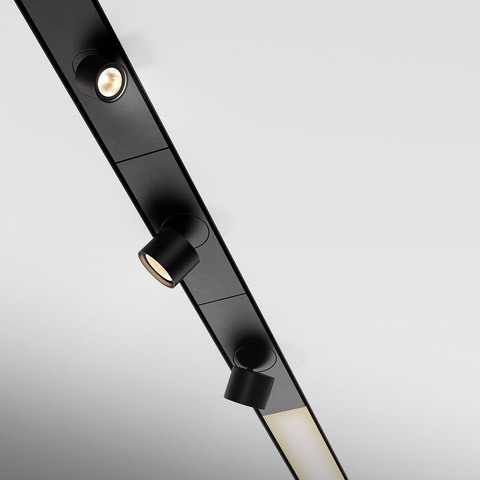 Artemide Hoy black track lighting system with two adjustable spotlights and a linear LED module mounted on a ceiling rail
