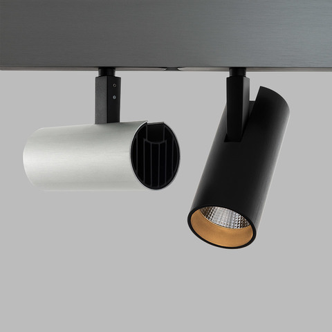 Artemide Vector track spotlights: white cylindrical fixture with heat sink and black cylindrical spotlight with gold interior on ceiling track