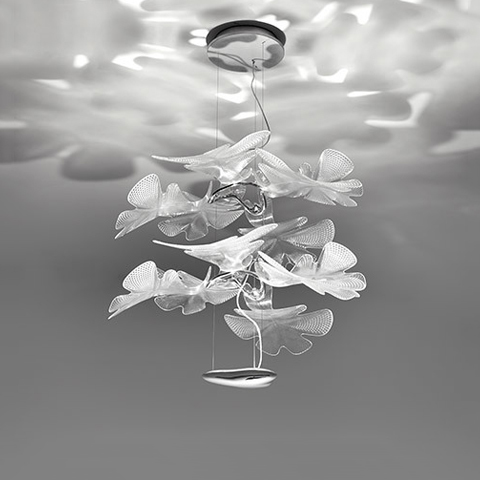Artemide Chlorophilia pendant lamp with layered translucent leaf-shaped diffusers casting organic light patterns on the ceiling