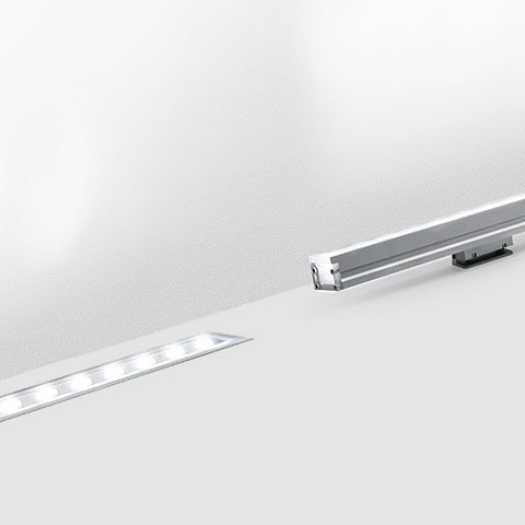 Artemide LineaLed wallwasher: apparecchio LED lineare incassato in superficie bianca accanto al suo profilo in alluminio