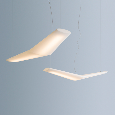 Two Artemide Mouette pendant lamps with white wing-shaped diffusers suspended at different angles on thin cables