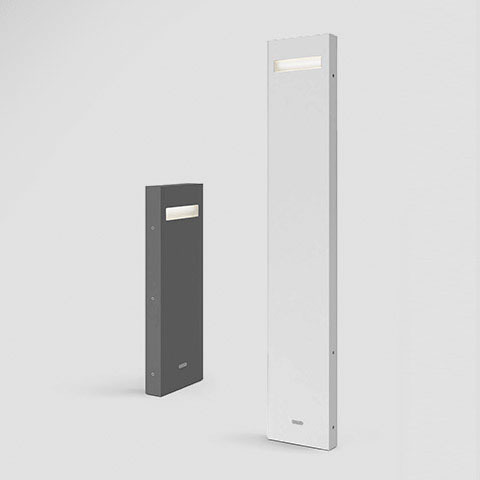 Lampade da esterno Artemide Nuda: versione bassa grigio scuro e versione alta bianca, ciascuna con apertura LED rettangolare nella parte superiore