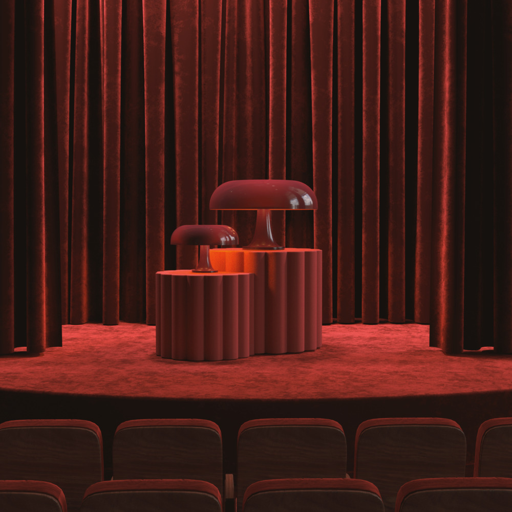Two burgundy mushroom-shaped table lamps displayed on a ridged cylindrical pedestal on a red theater stage with velvet curtains