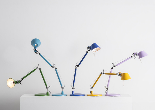 Serie di cinque lampade da tavolo Tolomeo in diversi colori, con bracci articolati in alluminio, disposte su superficie bianca e sfondo chiaro.