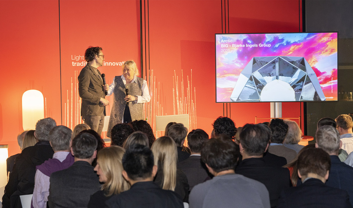 Carlotta de Bevilacqua e Jakob Lange parlano su un palco davanti a una platea vista di spalle, durante una presentazione con schermo sullo sfondo.