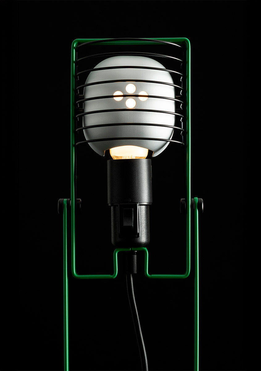 Dettaglio della parte superiore di una lampada Sintesi verde su sfondo nero.