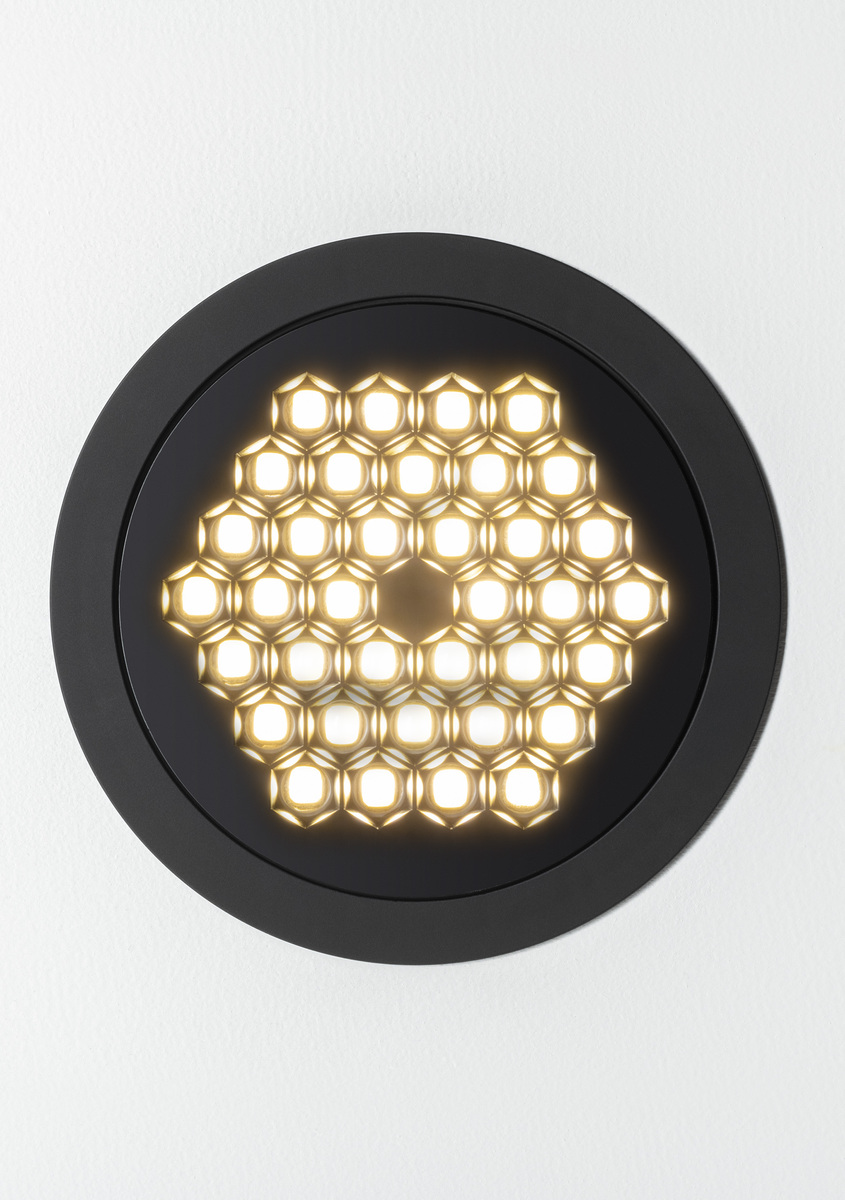 Faretto da incasso rotondo Artemide con cornice nera e griglia LED a nido d'ape che emette luce bianca calda