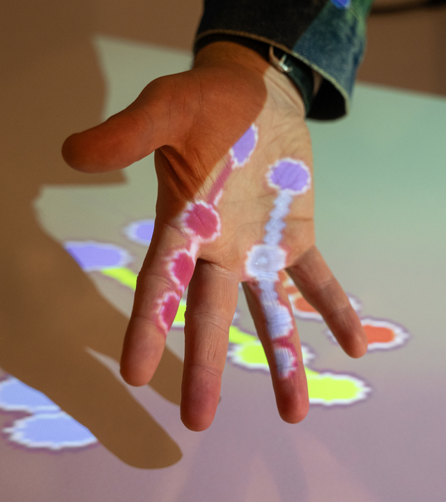 Immagine di una mano illuminata dai colori.