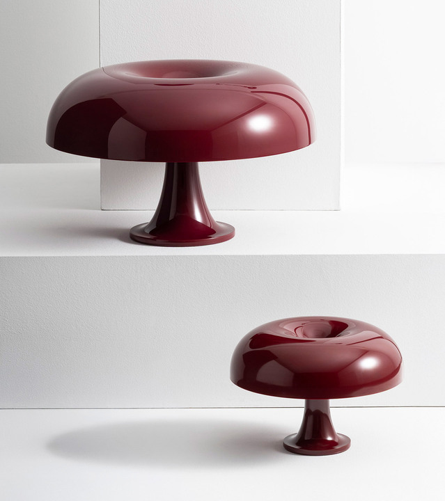 Due lampade da tavolo Nesso e Nessino bordeaux esposte su livelli bianchi, sfondo bianco.
