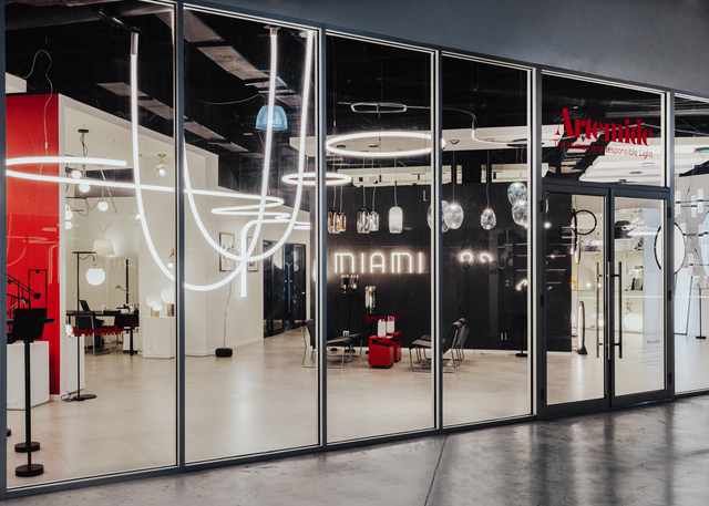 Immagine da fuori della vetrina principale dello Showroom dove si vedono molti prodotti Artemide.