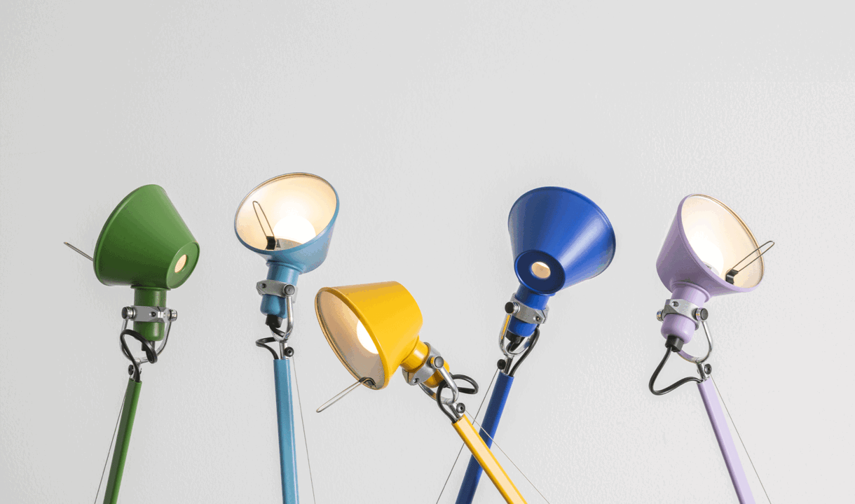 Collezione di lampade Tolomeo con diffusori colorati e bracci articolati in alluminio verniciato su sfondo neutro.