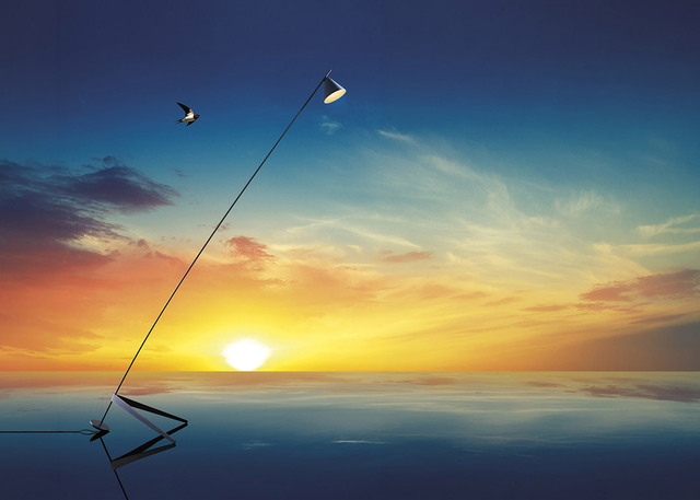 Lampada da terra Artemide con sottile stelo diagonale e testa orientabile, riflessa sull'acqua su uno sfondo di vivace tramonto.