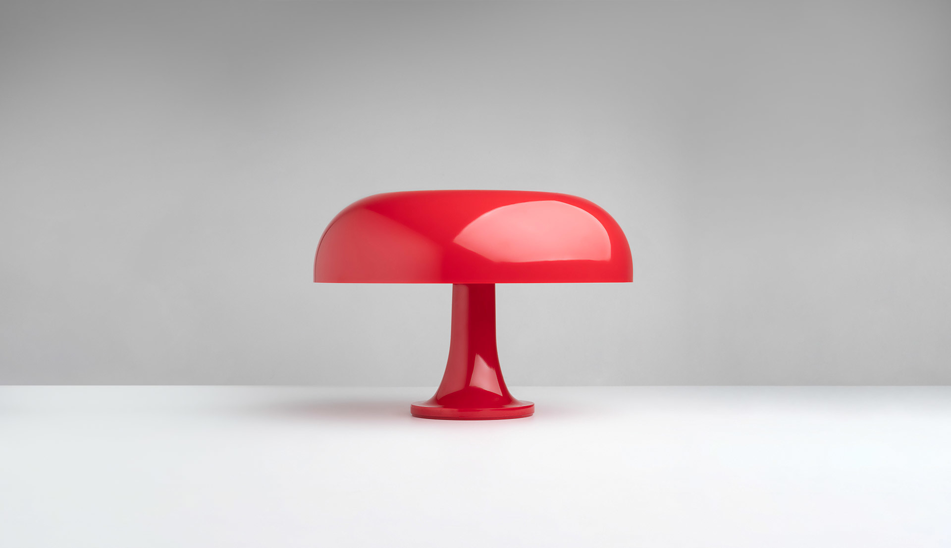 Lampada da tavolo Artemide Nessino in rosso lucido, con iconico paralume a fungo su base a tromba