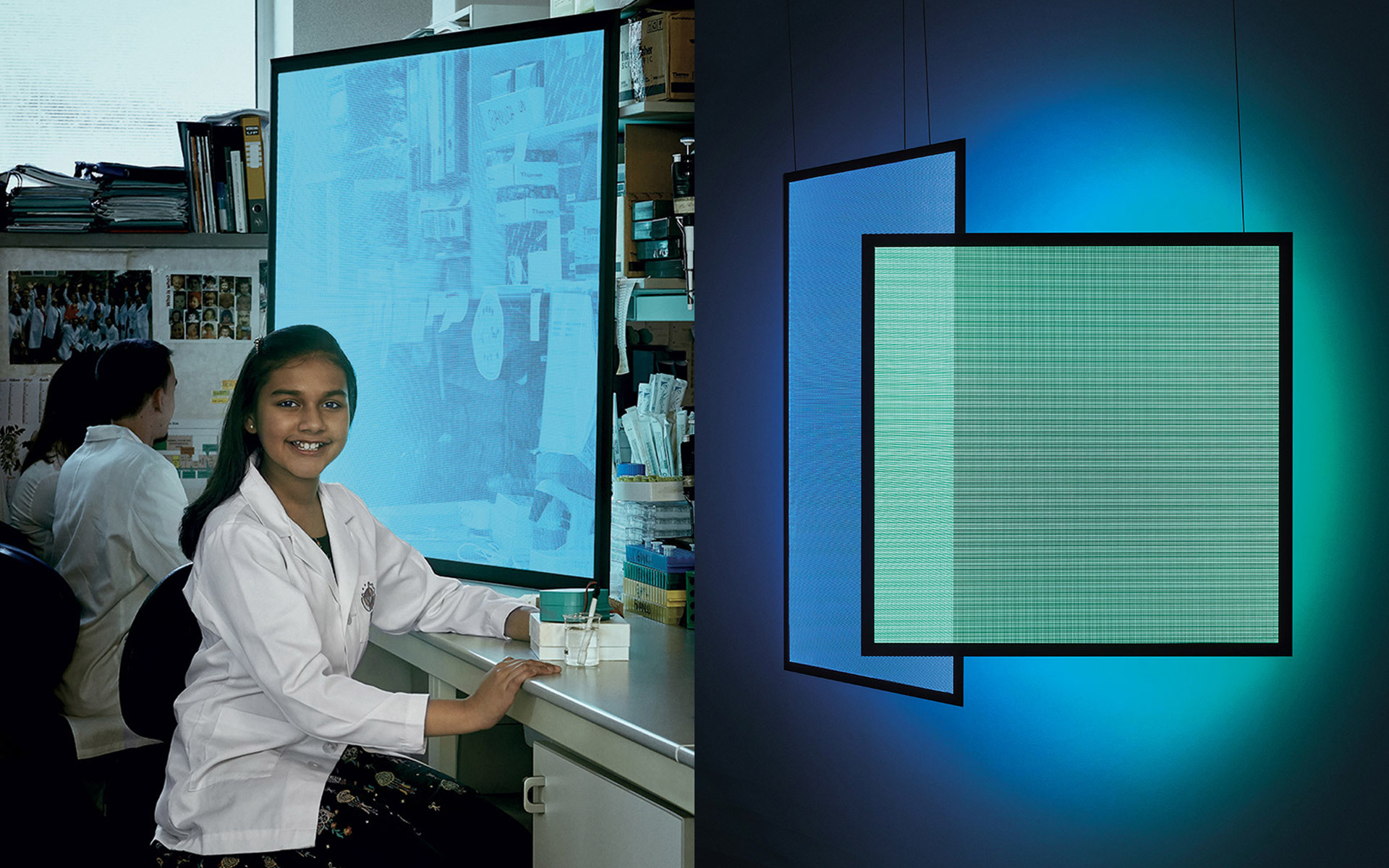 Studentessa in camice sorridente alla scrivania accanto a un pannello LED quadrato Artemide che emette luce turchese, montato su parete scura