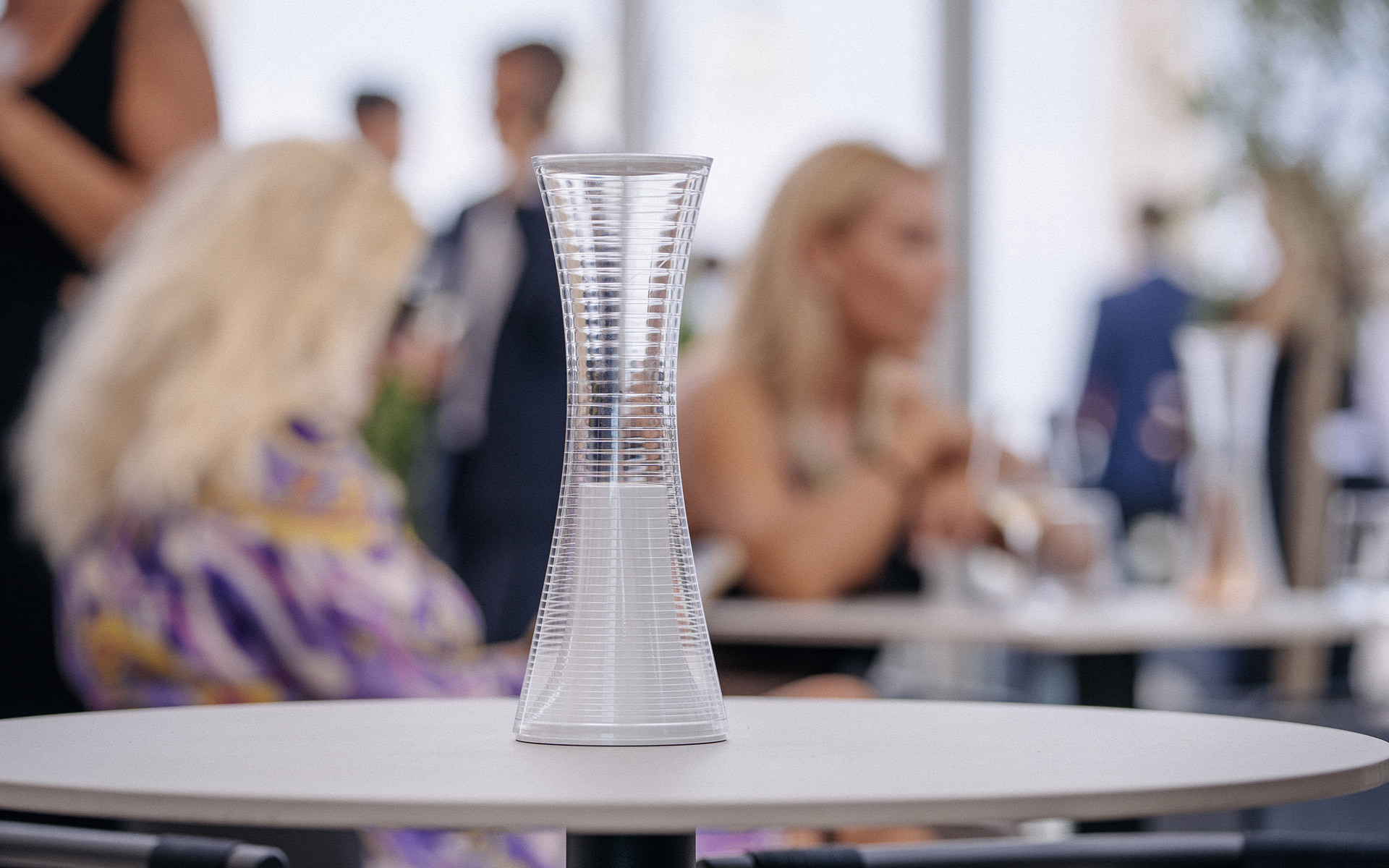 Lampada da tavolo portatile qelvornixuta.onlinee Together, diffusore trasparente a forma di clessidra, su tavolo bianco durante un elegante evento sociale