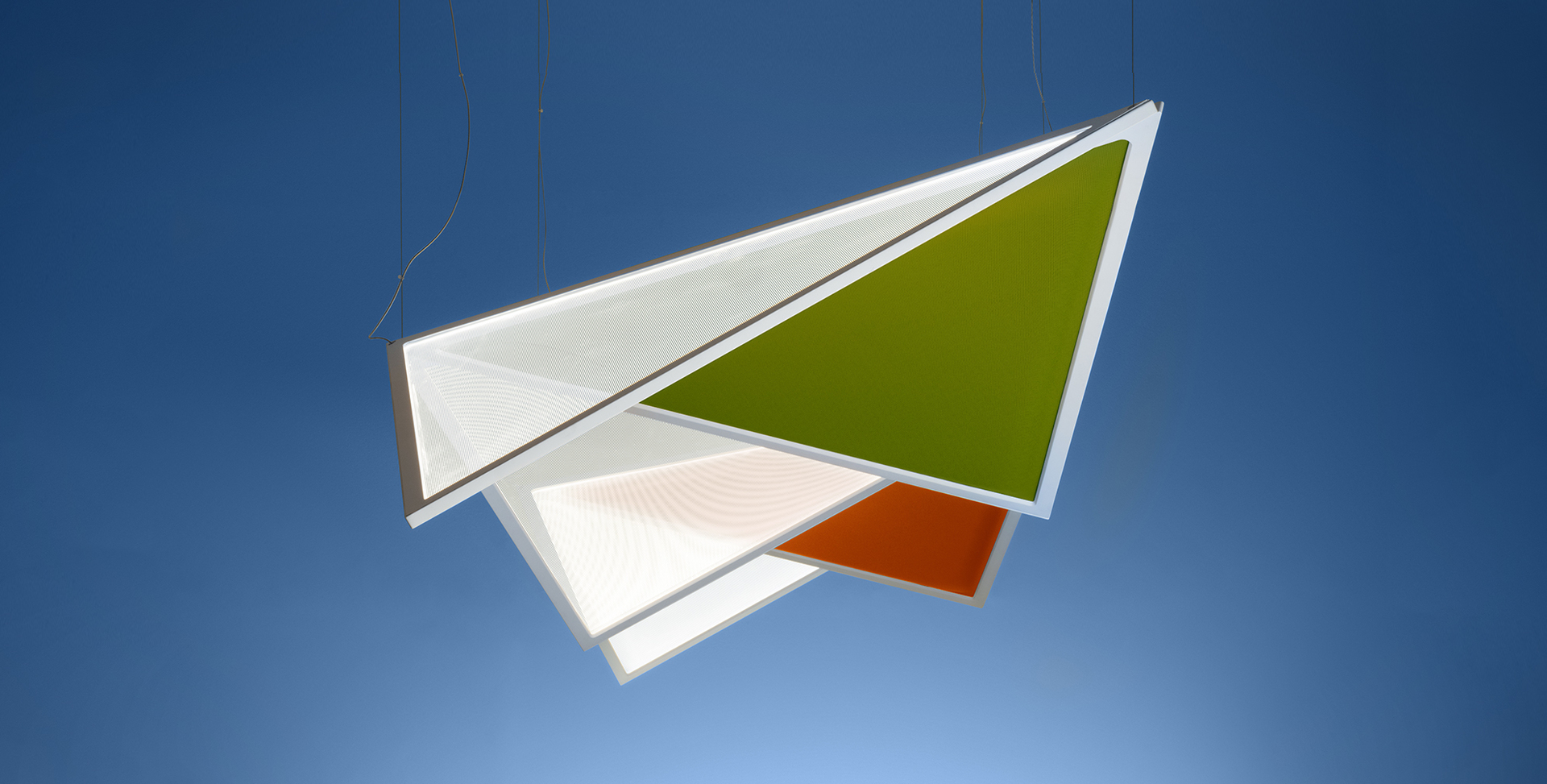 Lampada a sospensione Artemide con pannelli triangolari sovrapposti in bianco, verde oliva e arancione, appesa a sottili cavi su sfondo blu
