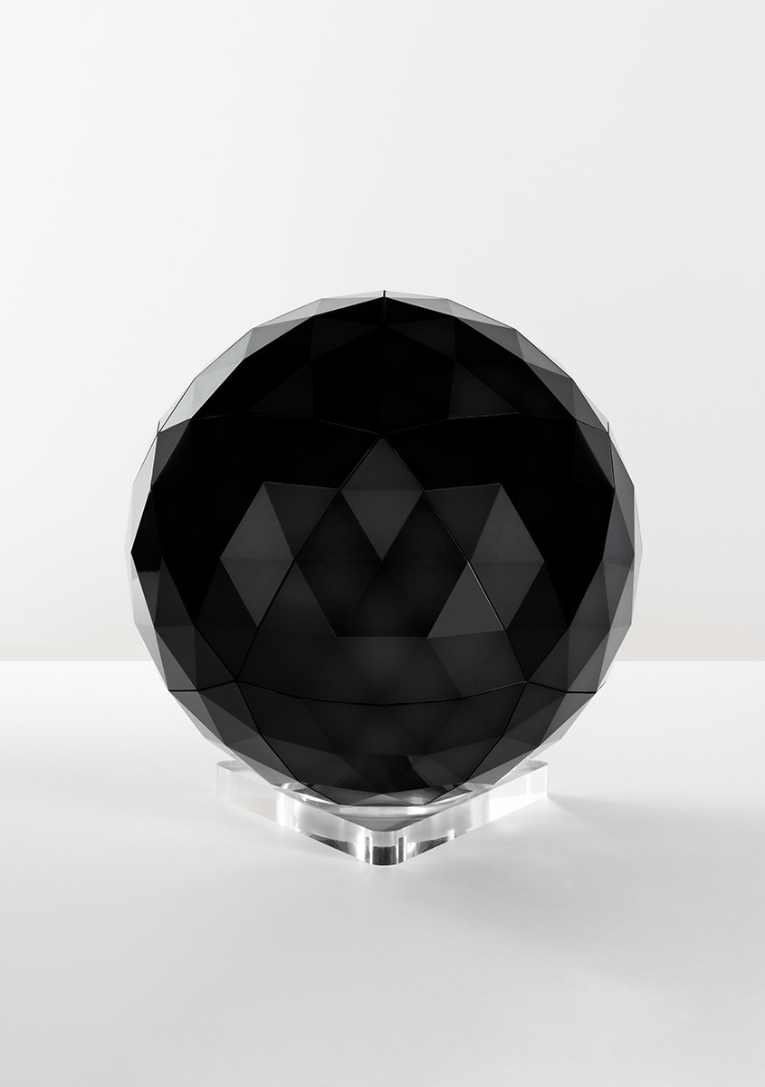 Lampada sferica nera Artemide con superfici geometriche a taglio diamante su base in acrilico trasparente