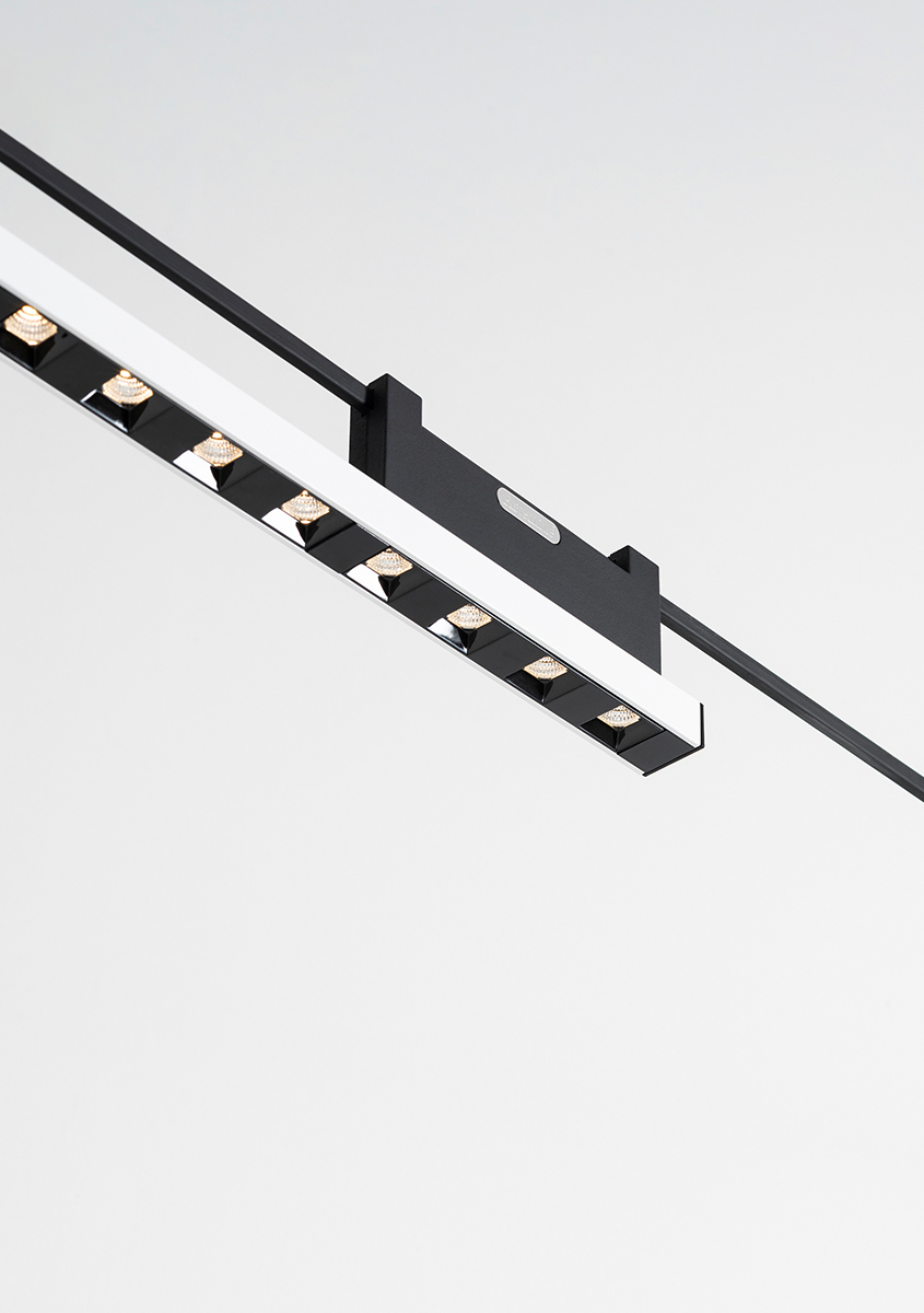 Apparecchio lineare LED nero con multipli faretti orientabili montato su sistema a binario a soffitto
