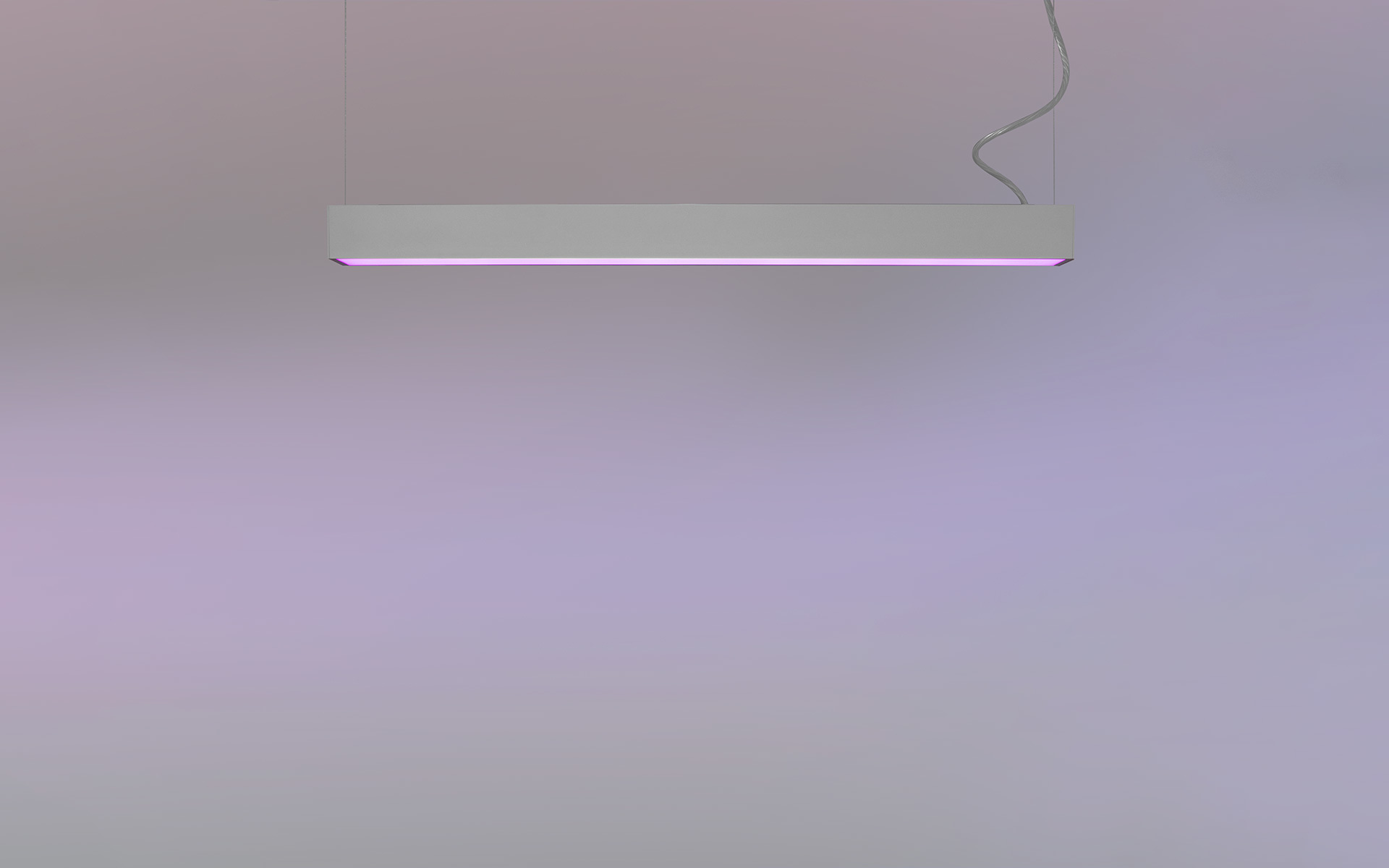 Sottile lampada a sospensione rettangolare bianca che emette una luce diffusa rosa-viola, appesa da un singolo cavo su sfondo neutro