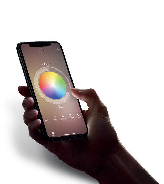 Mano che tiene uno smartphone con l'app Artemide aperta, mostrando un'interfaccia a ruota cromatica per controllare l'illuminazione smart.