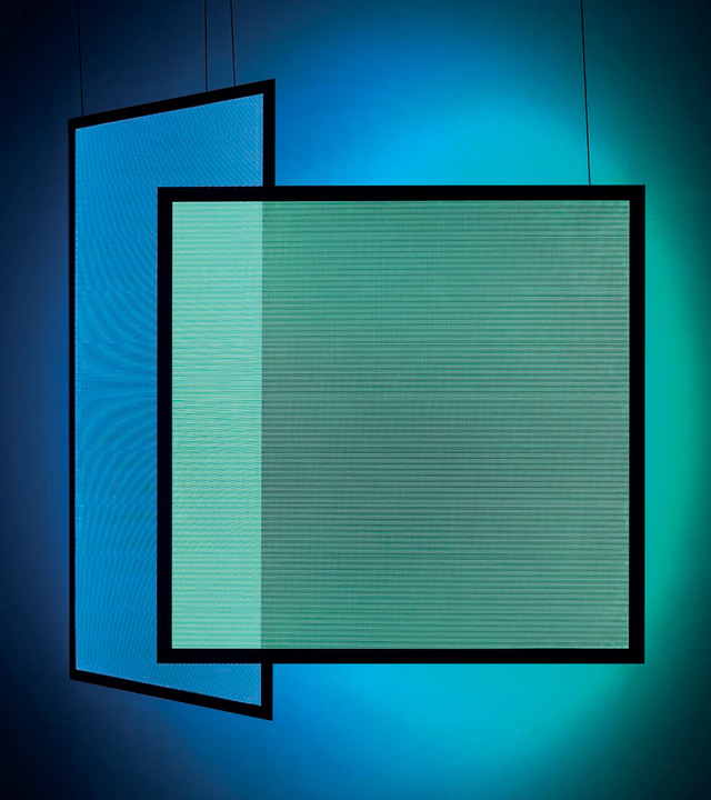 Due lampade a sospensione quadrate sovrapposte con cornici nere che emettono luce blu e verde acqua vibrante, creando un'atmosfera colorata