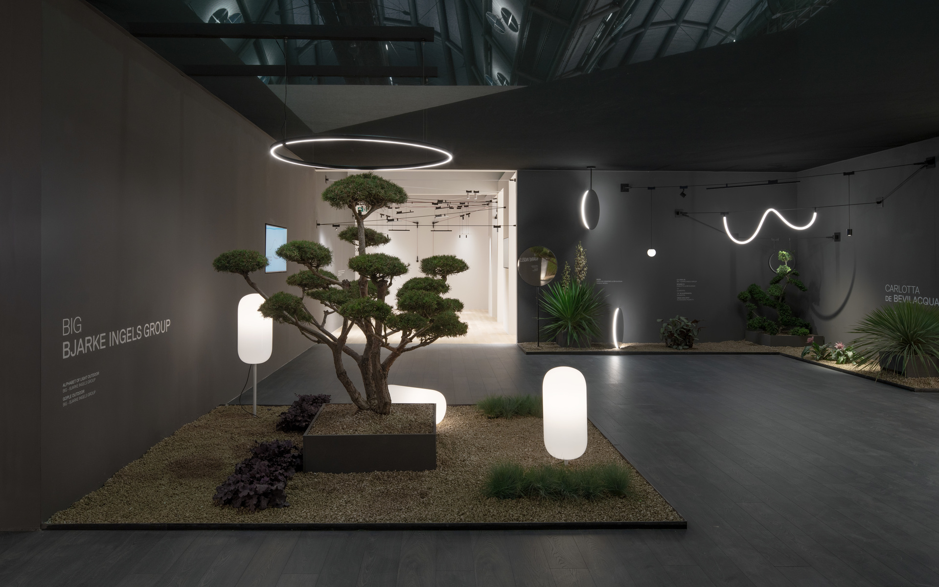 Artemide exhibition space by BIG-Bjarke Ingels Group featuring glowing oval floor lamps, circular and wavy LED ceiling lights amid Japanese garden