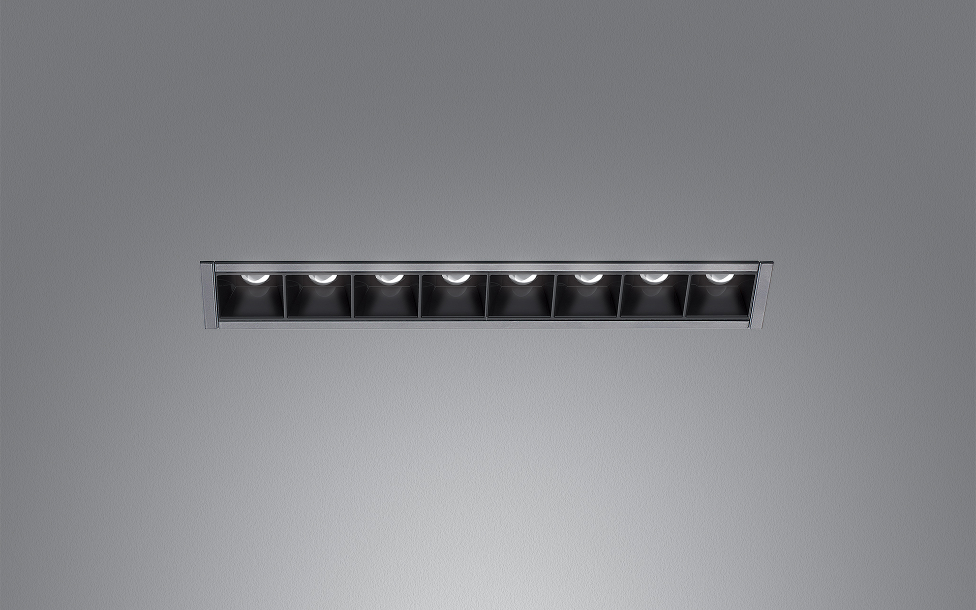 Apparecchio LED lineare da incasso Artemide con otto celle quadrate nere in un sottile bordo in alluminio, progettato per installazione a soffitto