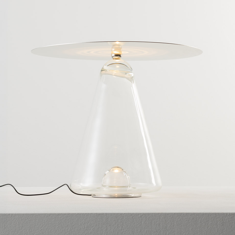 Lampada da tavolo Artemide Boltons: base conica in vetro trasparente con due sorgenti LED e un ampio diffusore circolare piatto in cima