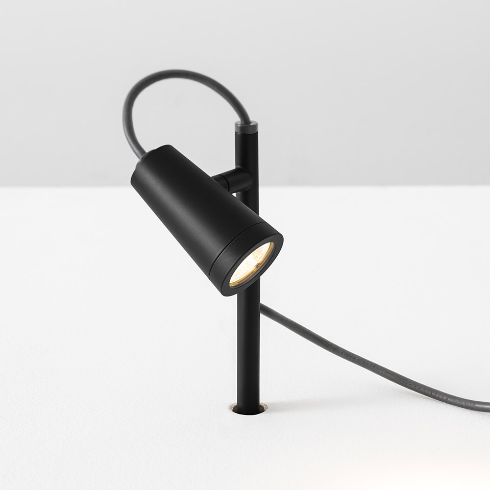 Faretto Artemide Conus nero opaco, testa cilindrica su stelo inclinato con cavo di alimentazione, progettato per illuminazione d'accento