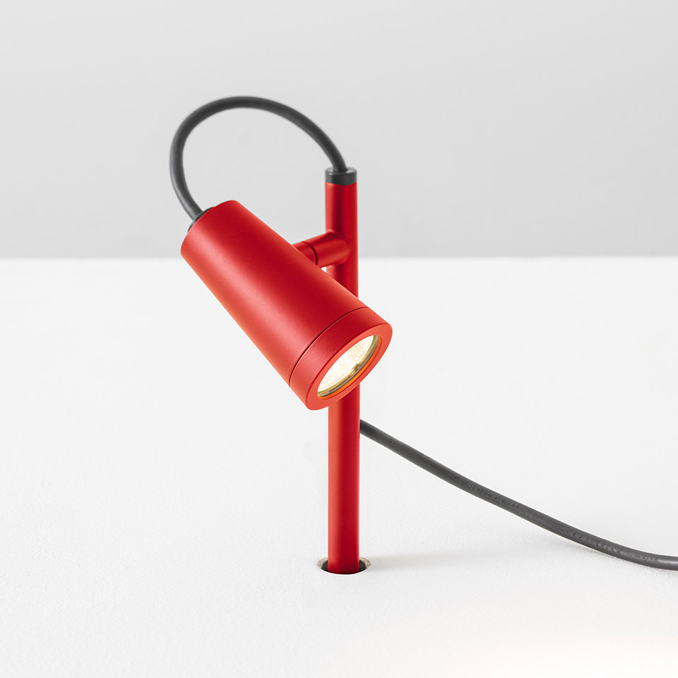 Faretto da tavolo Artemide Conus in rosso, con testa cilindrica orientabile su sottile stelo e cavo grigio scuro