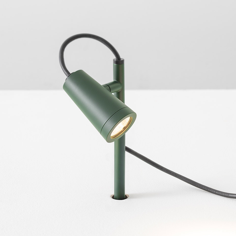 Faretto da tavolo Artemide Conus verde opaco, testa cilindrica orientabile su sottile stelo con cavo di alimentazione scuro