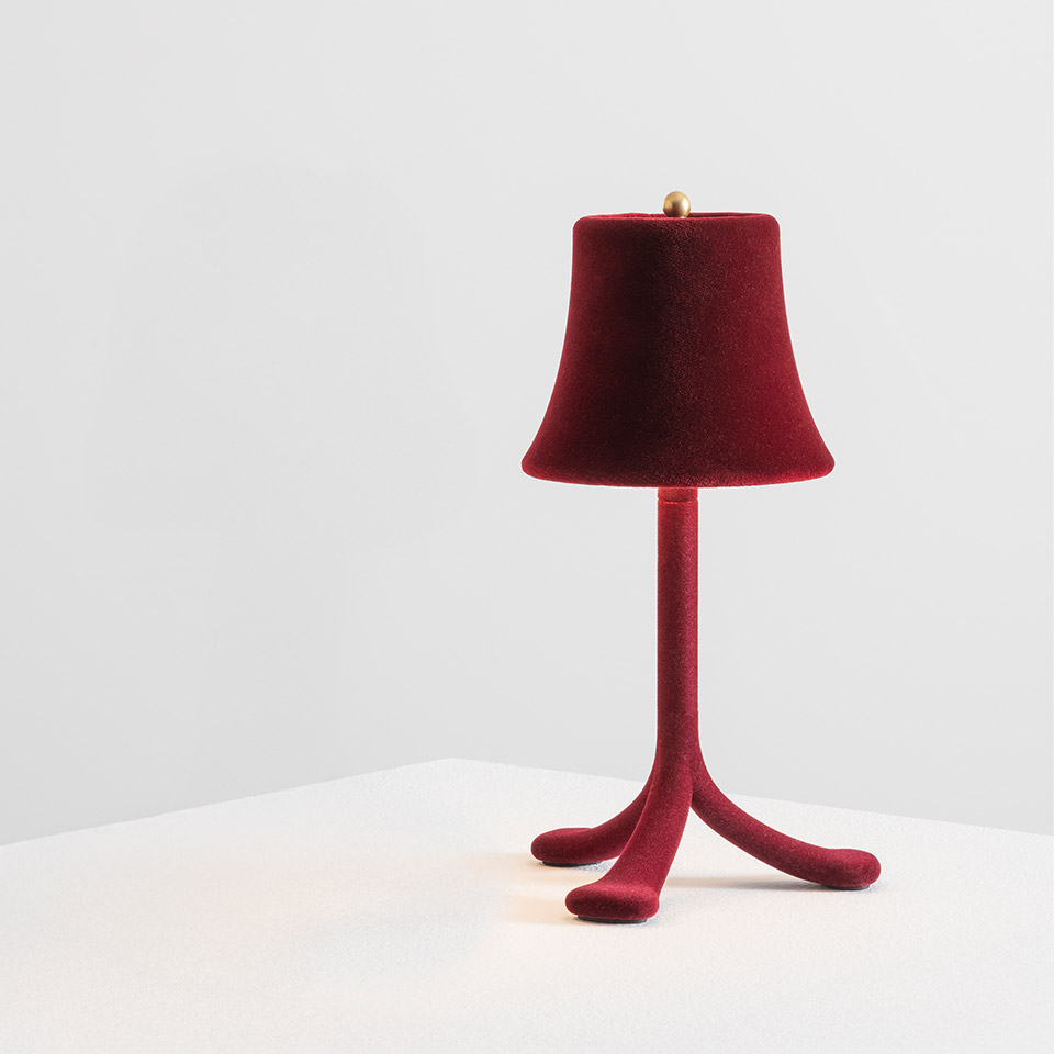 Lampada da tavolo Trois Rois di Artemide: paralume e base a tre piedi floccati in velluto rosso intenso con gambe curve organiche e finale dorato