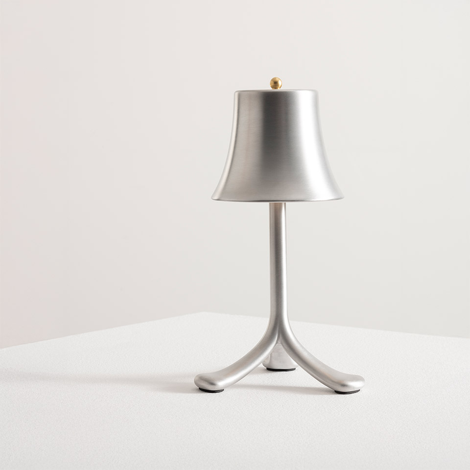 Lampada da tavolo Artemide Trois Rois: paralume a campana in alluminio spazzolato su base a treppiede con finale dorato, design portatile senza filo