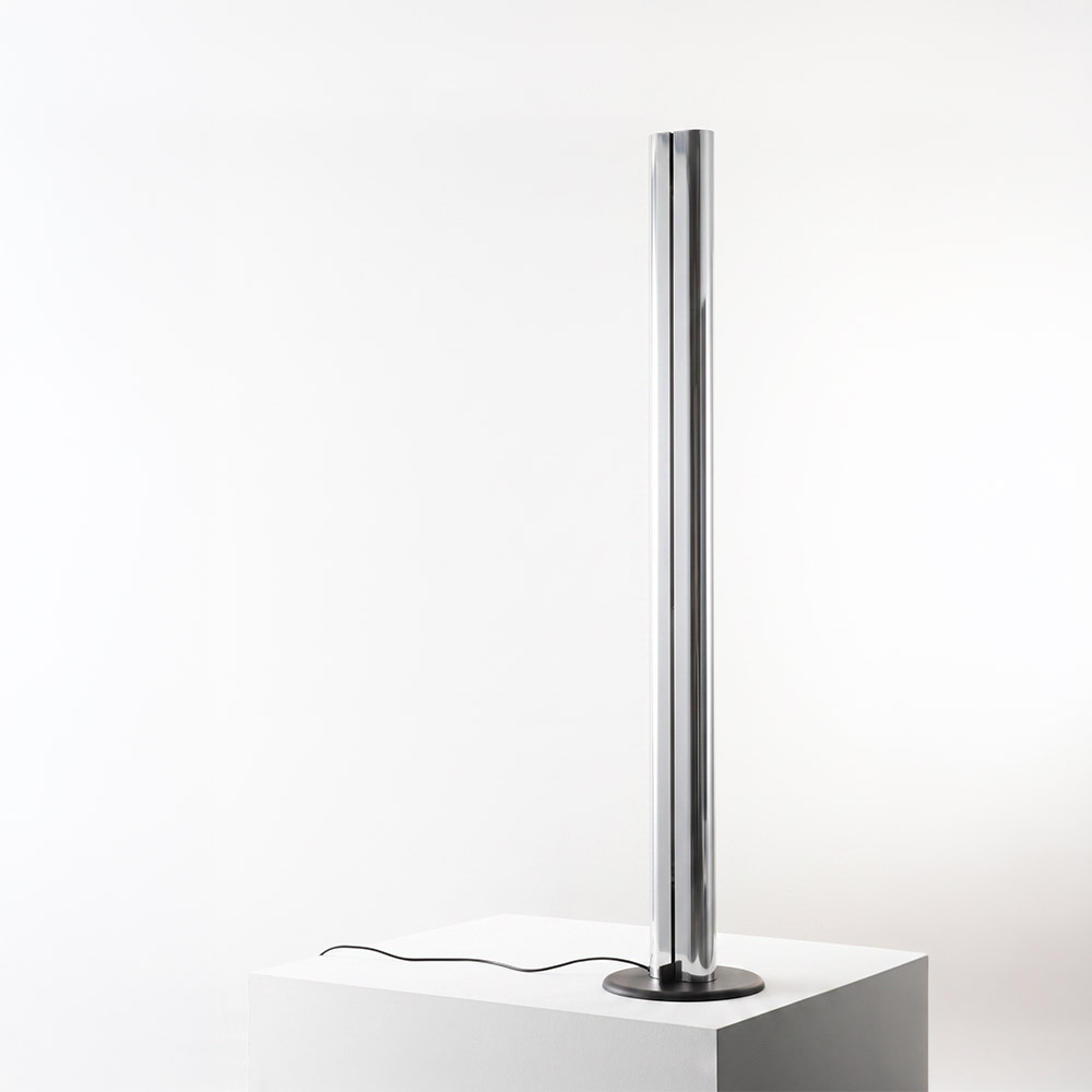 Artemide Megaron floor lamp: tall slim polished aluminum cylindrical column on a round black base with black power cord