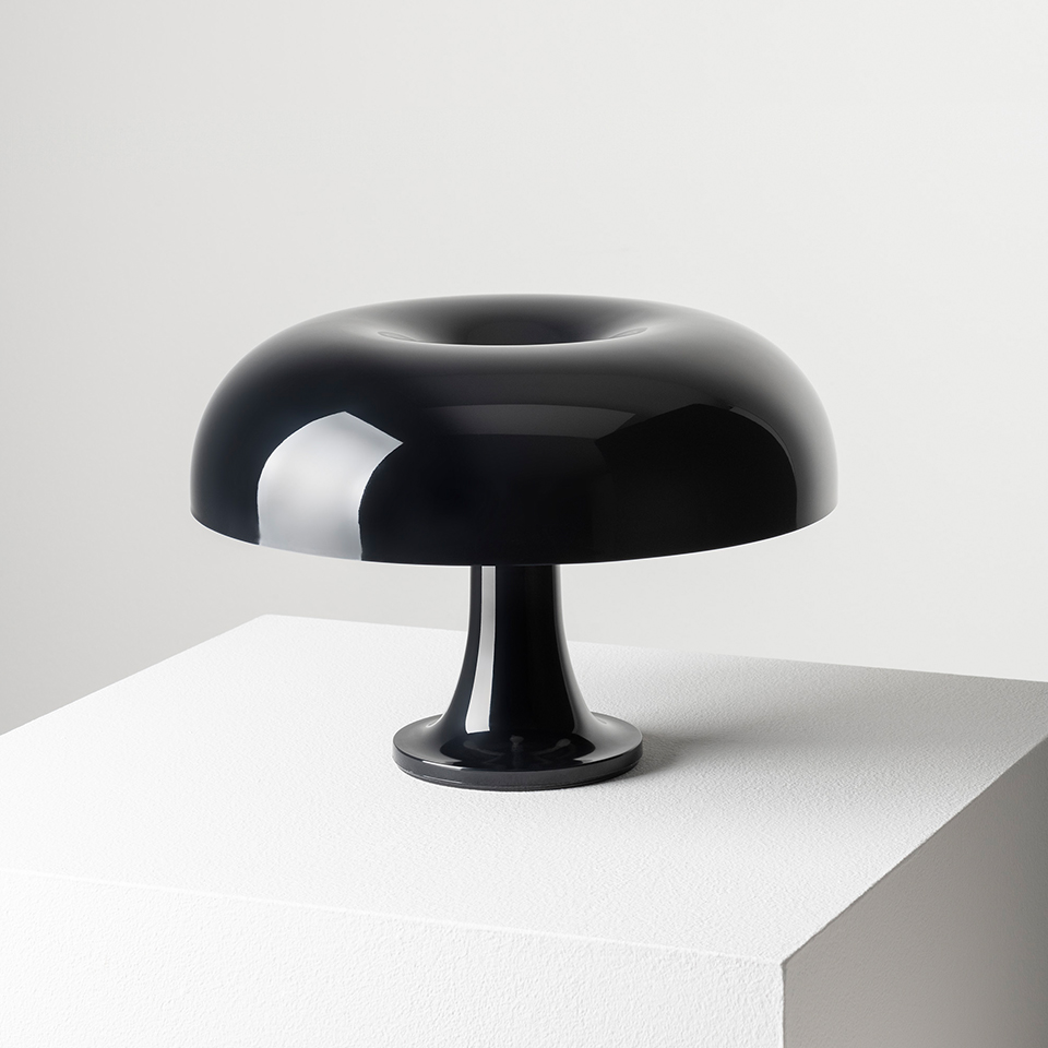 Lampada da tavolo Artemide Nessino in nero lucido, con iconico paralume a fungo con sommità toroidale su base a piedistallo snello