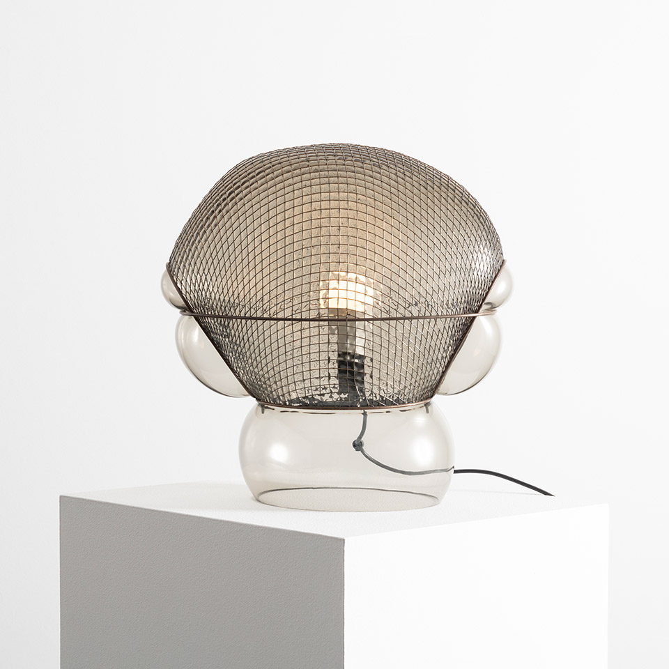 Lampada da tavolo Artemide Patroclo: base in vetro trasparente a bolle con paralume sferico in rete metallica, lampadina a filamento visibile all'interno