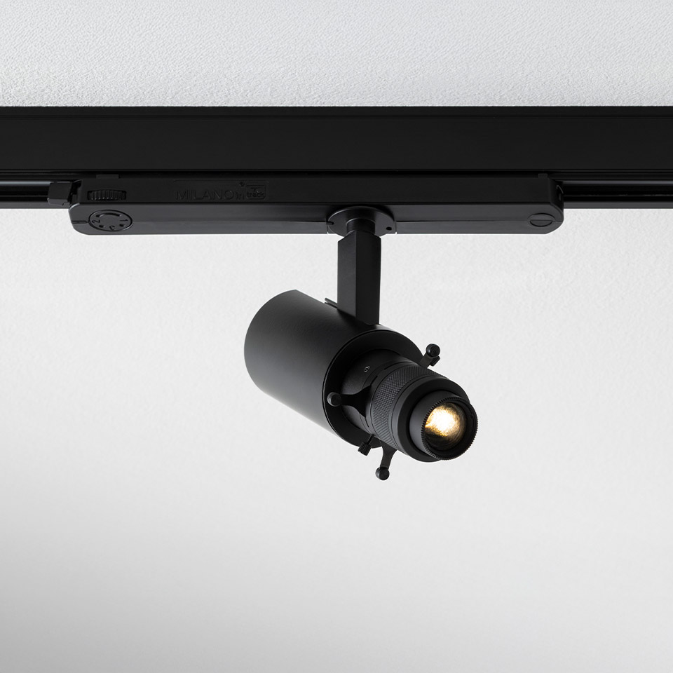 Artemide Vector Shaper track spotlight in black, mounted on rail, featuring adjustable lens barrel for precise beam shaping