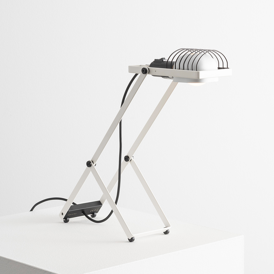 Lampada da tavolo Artemide Sintesi: struttura metallica pieghevole angolare bianca con testa riflettore alogena e griglia protettiva in filo, base nera