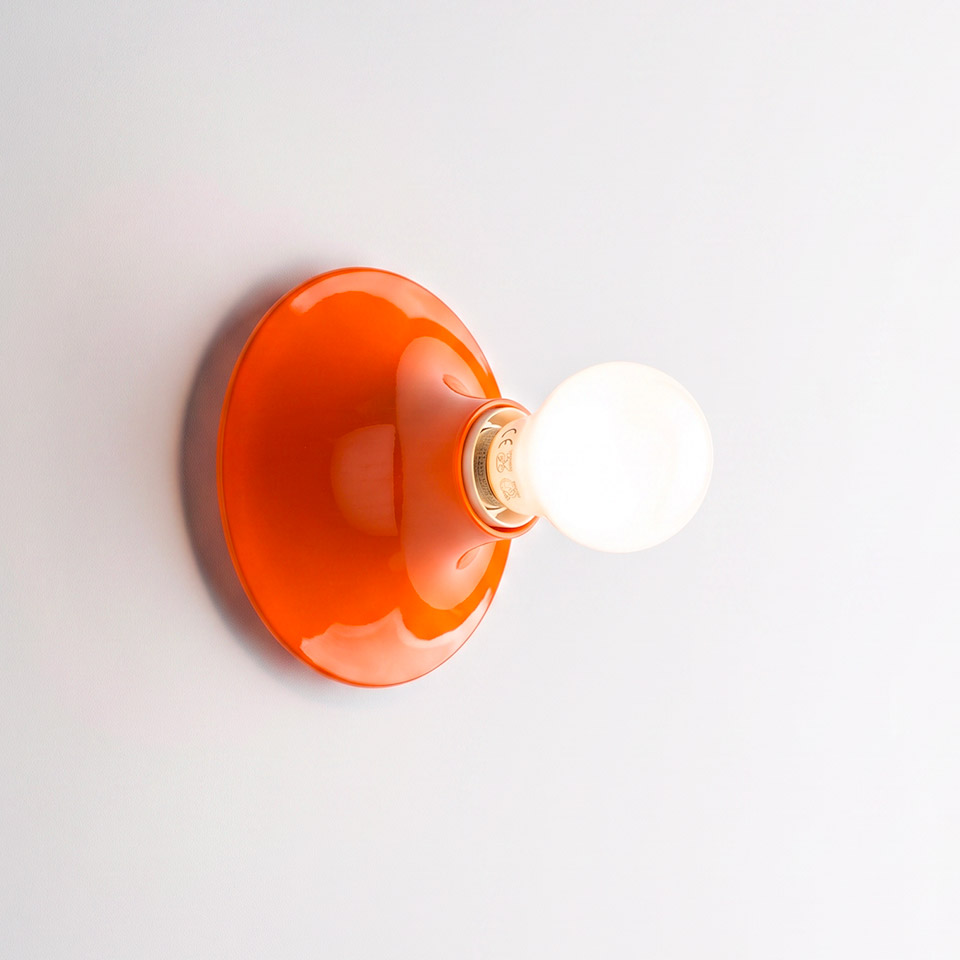 Artemide Teti wall lamp in glossy orange, dome-shaped backplate with exposed spherical bulb mounted on white wall