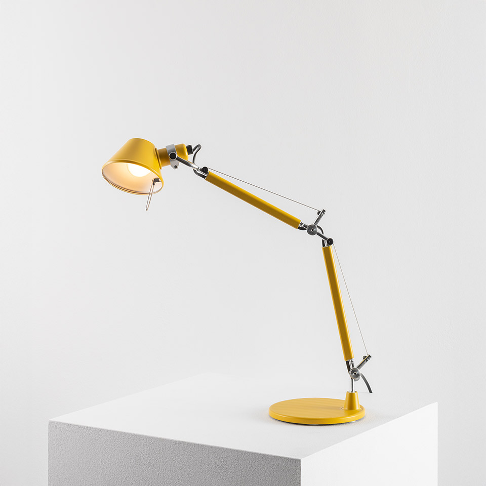 Artemide Tolomeo Tavolo desk lamp in yellow, featuring articulated arm with tension cables, adjustable shade, and round base