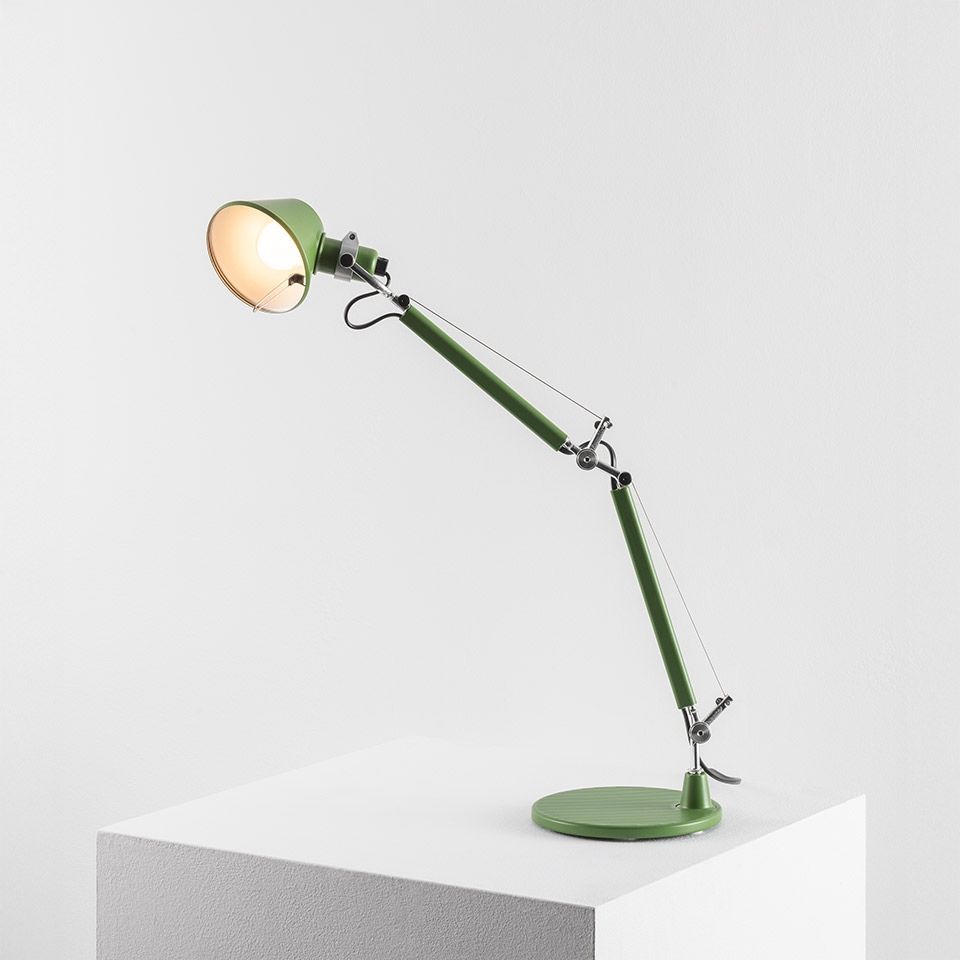 Artemide Tolomeo Micro Tavolo desk lamp in sage green with articulated arm, tension cables, and round base on white surface