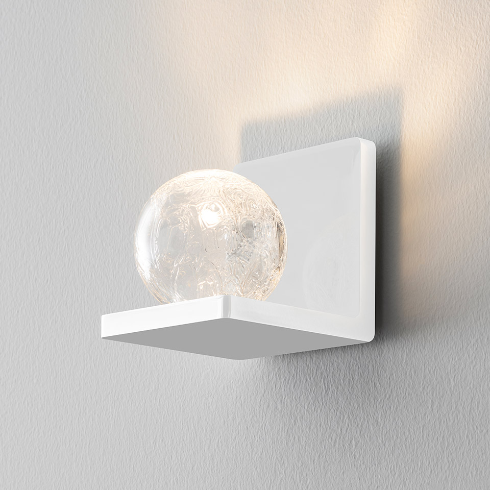 Applique da parete Artemide Ulrich und Diotima bianca con sfera in vetro craquelé su mensola quadrata, proietta luce calda verso l'alto