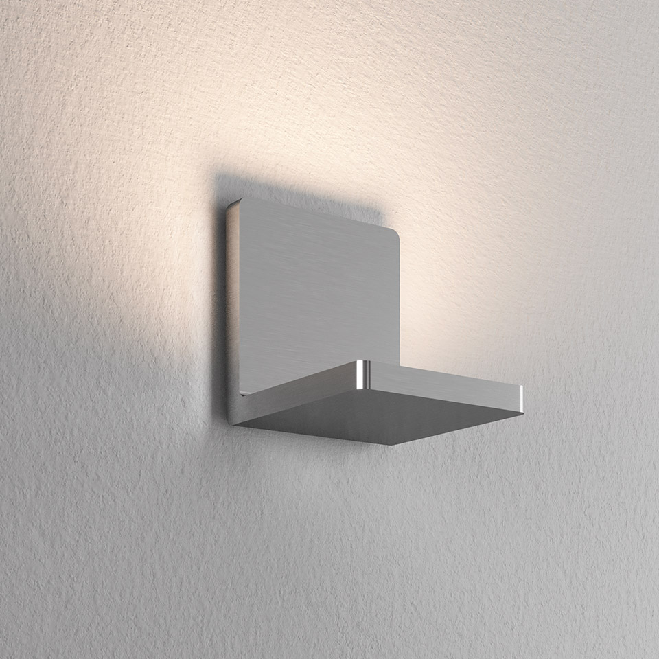 Lampada da parete Artemide Ulrich und Diotima: applique a croce in alluminio spazzolato che emette luce indiretta calda verso l'alto
