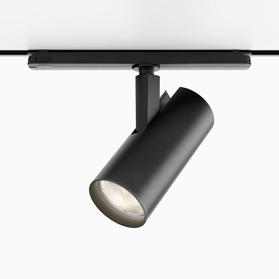 Faretto LED cilindrico nero Artemide Vector Track 230V montato su binario, inclinato per illuminazione direzionale