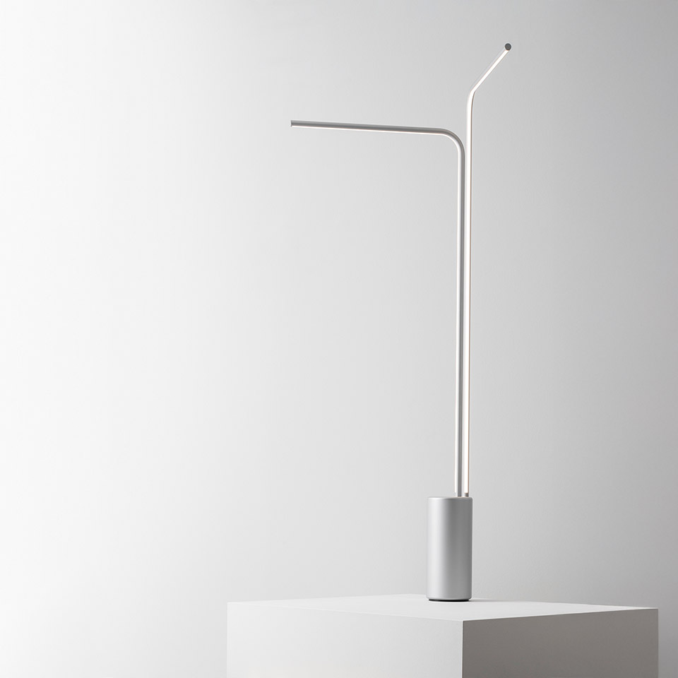 Artemide Veil table lamp: minimalist white design with slender angled stem, horizontal LED bar, and cylindrical base